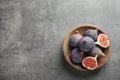 Bowl with fresh ripe figs on gray background, top view