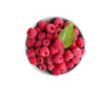 Bowl of fresh ripe raspberries with green leaf isolated on white, top view Royalty Free Stock Photo