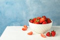 Bowl with fresh strawberries on white table against blue background, space for text. Summer sweet fruits Royalty Free Stock Photo