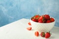 Bowl with fresh strawberries on white table against blue background, space for text. Summer sweet fruits Royalty Free Stock Photo
