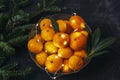 Bowl with fresh tangerines, Christmas lights and fir branches. Top view