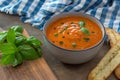 A bowl of fresh tomato soup in white ceramic bowl, garnished with basil, croutons, seasoning and a drizzle of olive oil Royalty Free Stock Photo