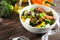 Bowl with fresh vegetable salad and measuring tape on table. Diet food Royalty Free Stock Photo