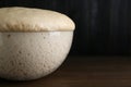 Bowl of fresh yeast dough on wooden table, closeup. Space for text Royalty Free Stock Photo