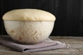 Bowl of fresh yeast dough on wooden table. Space for text Royalty Free Stock Photo