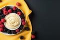 Yogurt and berry bowls with spoon and towel on bright white and yellow background, space for text