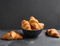 Bowl of freshly baked croissants, on a dark gray background. Delicious breakfast. Royalty Free Stock Photo