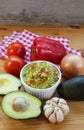 Bowl of Guacamole Surrounded with Fresh Avocadoes and Another Ingredients Royalty Free Stock Photo
