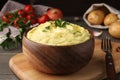 Bowl of freshly cooked mashed potatoes with parsley served on wooden table, closeup