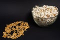 A bowl of fried popcorn and corn kernels on a black background Royalty Free Stock Photo