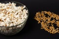 A bowl of fried popcorn and corn kernels on a black background Royalty Free Stock Photo