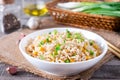 Bowl of fried rice, corn and egg on a wooden background. Healthy and light.