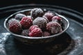A bowl of frozen raspberries sitting on a table. Generative AI image. Royalty Free Stock Photo