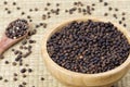 Bowl full of black peppercorns on a bamboo background Royalty Free Stock Photo