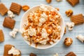 Bowl full of delicious popcorn with caramel on wooden background, top view Royalty Free Stock Photo