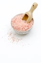 bowl full of pink bath salts, spoon, grains of salt fallen, on white background frontal view Royalty Free Stock Photo