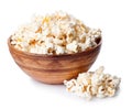 Bowl full of popcorn with heap of popcorn isolated on white back