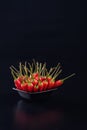 Bowl full of red chili peppers on a black background