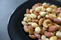 a bowl full of roasted hazelnuts, pistachios, cashews and a plate of various nuts Royalty Free Stock Photo