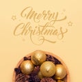 Bowl of golden christmas baubbles and pine cones isolated over beige background. Golden christmas ornaments. Royalty Free Stock Photo