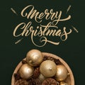 Bowl of golden christmas baubbles and pine cones isolated over dark green background. Golden christmas ornaments. Royalty Free Stock Photo