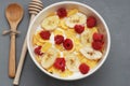 Bowl of Granola Cereals with Yogurt or Milk on Gray Background with wooden Spoon and Honey. Morning Breakfast. Royalty Free Stock Photo