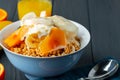 Bowl of granola with youghurt and sliced fruits