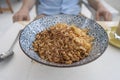 Bowl with granules and coconut and chocolate chips for a healthy breakfast. Male hand with a spoon and a plate with muesli Royalty Free Stock Photo