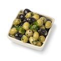Bowl with green and black olives seasoned with garlic and herbs on white background Royalty Free Stock Photo