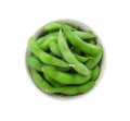 Bowl with green edamame pods on white background, top view