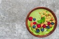 Bowl of green matcha tea smoothie with fresh berries, fruits, granola, nuts and seeds for healthy vegan breakfast Royalty Free Stock Photo