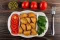 Bowl with green peas, row of  tomatoes, partitioned dish with patties, parsley, tomato, fork on table. Top view Royalty Free Stock Photo