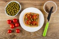 Bowl with green peas, sandwich with meat pate and tomato in plate, knife on jar with meat pate, tomates cherry on table. Top view Royalty Free Stock Photo
