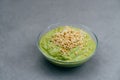 Bowl of green smoothie made Of spinach with buckwheat sprouts on grey background. Vegan food. Healthy eating and nutrition concept Royalty Free Stock Photo