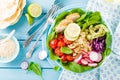 Bowl with grilled chicken meat, bulgur and fresh vegetable salad of radish, tomatoes, avocado, kale and spinach leaves