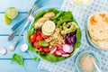 Bowl with grilled chicken meat, bulgur and fresh vegetable salad of radish, tomatoes, avocado, kale and spinach leaves