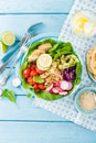 Bowl with grilled chicken meat, bulgur and fresh vegetable salad of radish, tomatoes, avocado, kale and spinach leaves