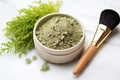 bowl of ground herbs next to a clean makeup brush