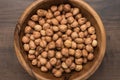 Close-up photo of a bowl full of hazelnuts on the brown wooden table Royalty Free Stock Photo