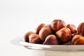 A bowl of hazelnuts on a white background