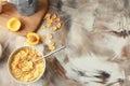 Bowl with healthy cornflakes, milk and peaches on color table Royalty Free Stock Photo