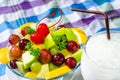 Bowl of healthy fresh fruit salad and milk on pattern of Thai hand made fabric background Royalty Free Stock Photo