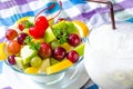 Bowl of healthy fresh fruit salad and milk on pattern of Thai hand made fabric background. Royalty Free Stock Photo