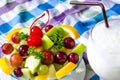 Bowl of healthy fresh fruit salad and milk on pattern of Thai hand made fabric background. Royalty Free Stock Photo