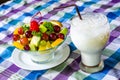 Bowl of healthy fresh fruit salad and milk on pattern of Thai hand made fabric background. Royalty Free Stock Photo