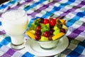 Bowl of healthy fresh fruit salad and milk on pattern of Thai hand made fabric background. Royalty Free Stock Photo