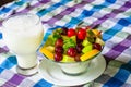 Bowl of healthy fresh fruit salad and milk on pattern of Thai hand made fabric background. Royalty Free Stock Photo