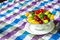 Bowl of healthy fresh fruit salad on pattern of Thai hand made fabric background Royalty Free Stock Photo
