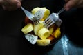 Bowl of healthy fresh fruit salad on wooden background. Man eating it with two forks. Royalty Free Stock Photo