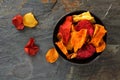 Bowl of healthy vegetable chips, top view on dark stone Royalty Free Stock Photo